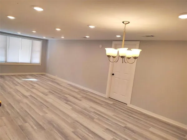 a view of a room with wooden floor and mirror