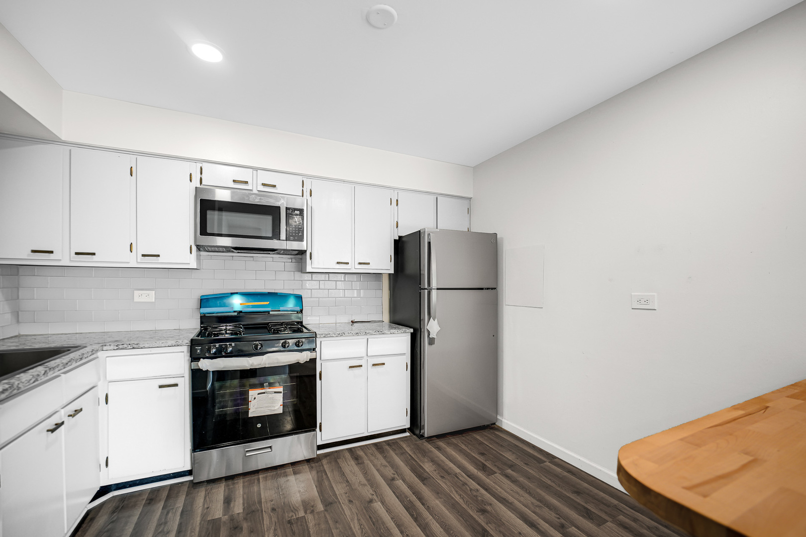 1133 South Finley Road, Unit 310 Lombard, IL 60148 - Photo 8 of 29 a kitchen with a refrigerator sink and white cabinets