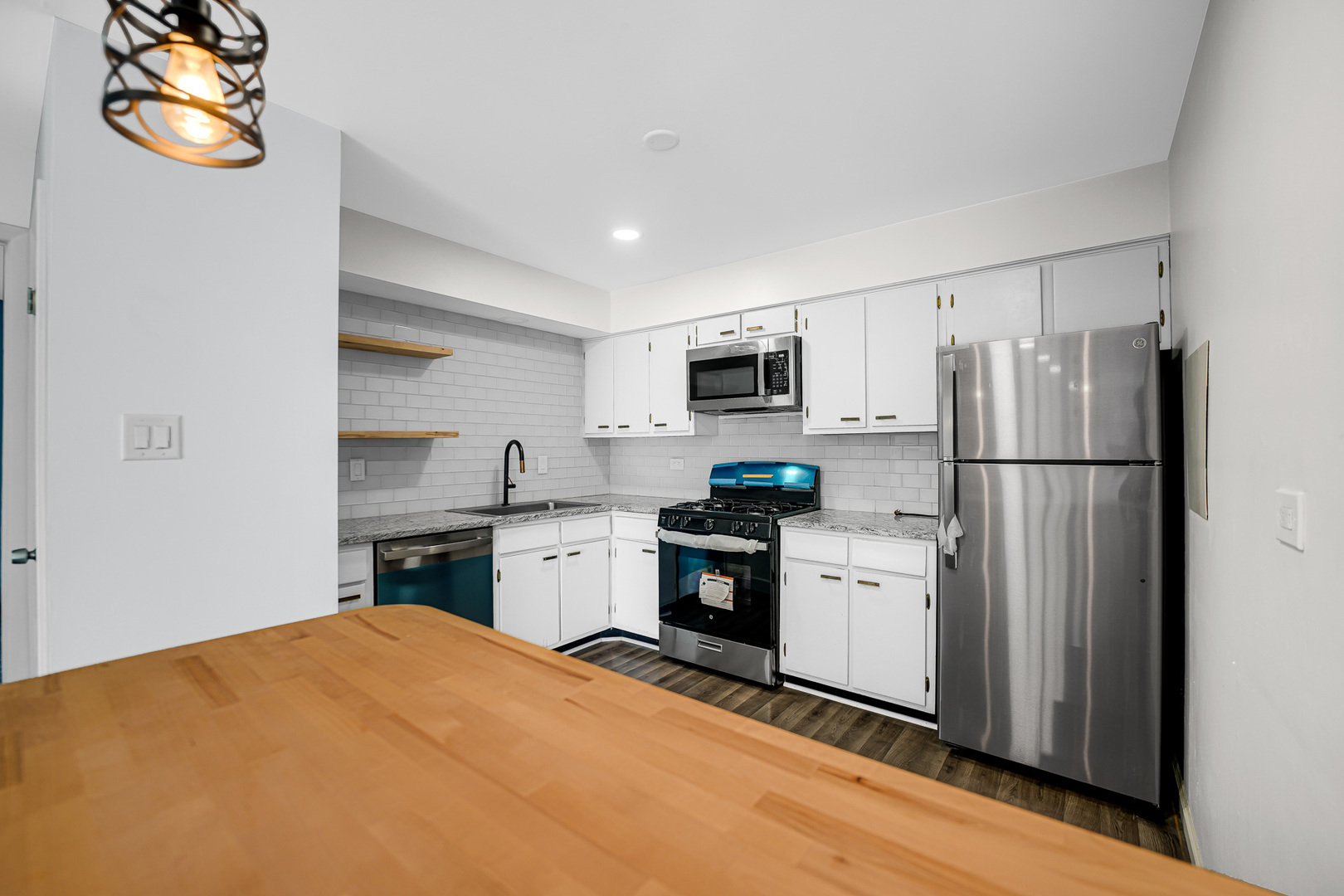 1133 South Finley Road, Unit 310 Lombard, IL 60148 - Photo 9 of 29 a kitchen with stainless steel appliances granite countertop a refrigerator sink stove and microwave