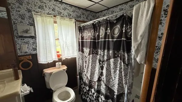 a bathroom with a toilet and a shower