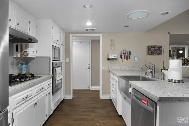 a kitchen with stainless steel appliances granite countertop a sink stove and refrigerator