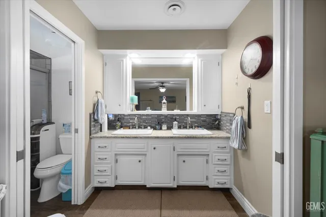 a bathroom with a double vanity sink mirror and a toilet