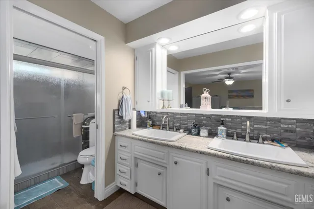 a bathroom with a double vanity sink toilet and shower