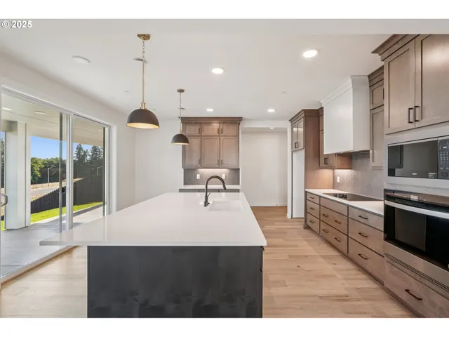 a kitchen with stainless steel appliances kitchen island granite countertop a sink and a stove
