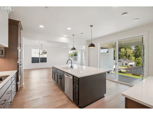 a large kitchen with kitchen island a large counter space a sink appliances and living room view