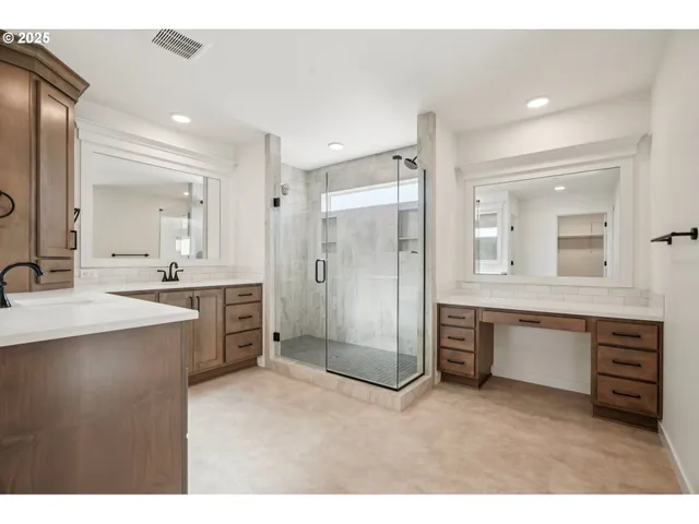 a bathroom with a granite countertop sink mirror and shower