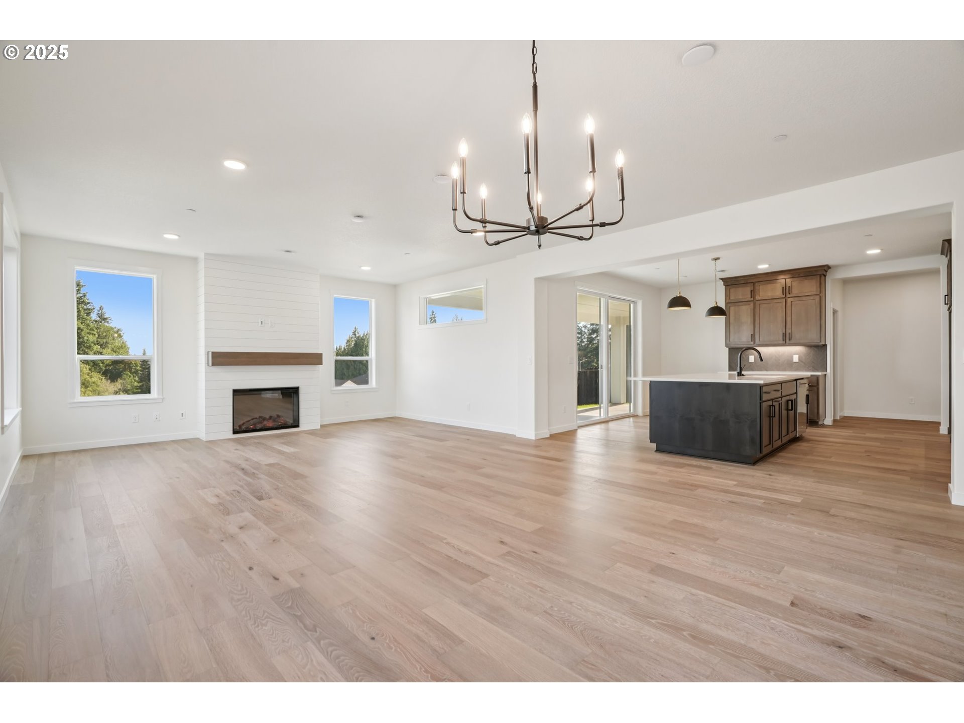 410 West 20th Way La Center, WA 98629 - Photo 5 of 43 a view of empty room with wooden floor fireplace and kitchen view
