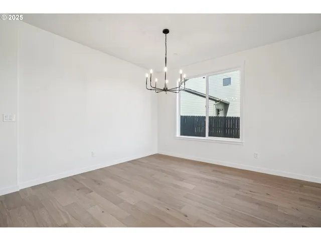 a view of a room with wooden floor and chandelier