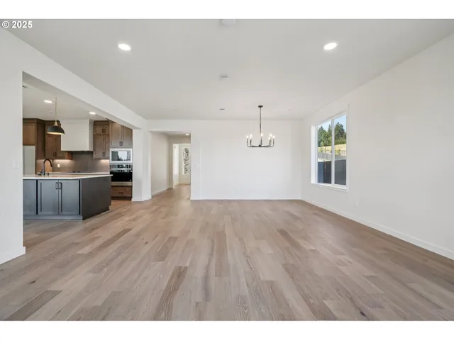 a view of a kitchen with wooden floor and a window