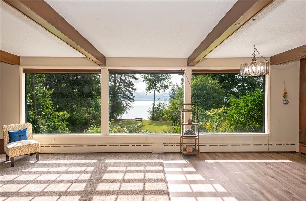 5130 London Road Duluth, MN 55804 - Photo 12 of 45 Unfurnished sunroom featuring beam ceiling, healthy amount of natural light, a chandelier, and a water view