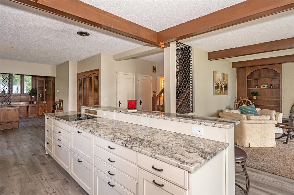 5130 London Road Duluth, MN 55804 - Photo 43 of 45 Kitchen with open floor plan, white cabinetry, a textured ceiling, beam ceiling, and light stone countertops