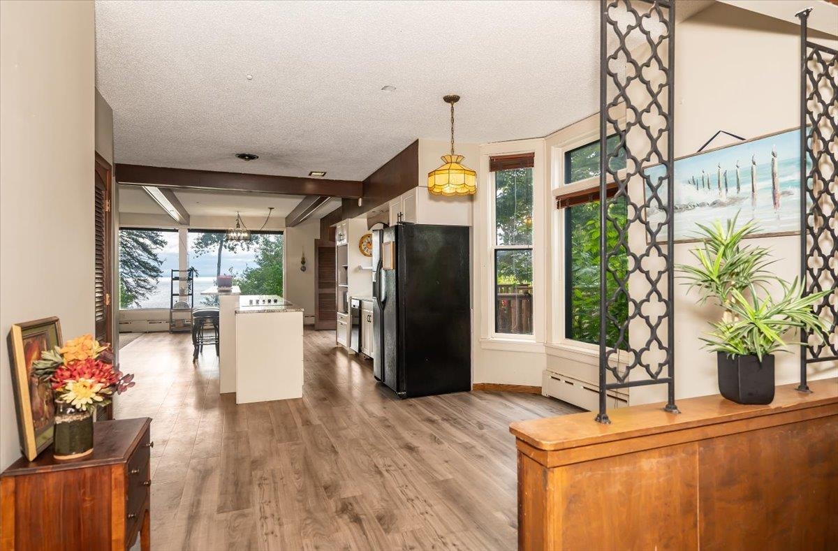 5130 London Road Duluth, MN 55804 - Photo 15 of 45 Kitchen featuring decorative light fixtures, black fridge, light wood finished floors, a chandelier, and a textured ceiling