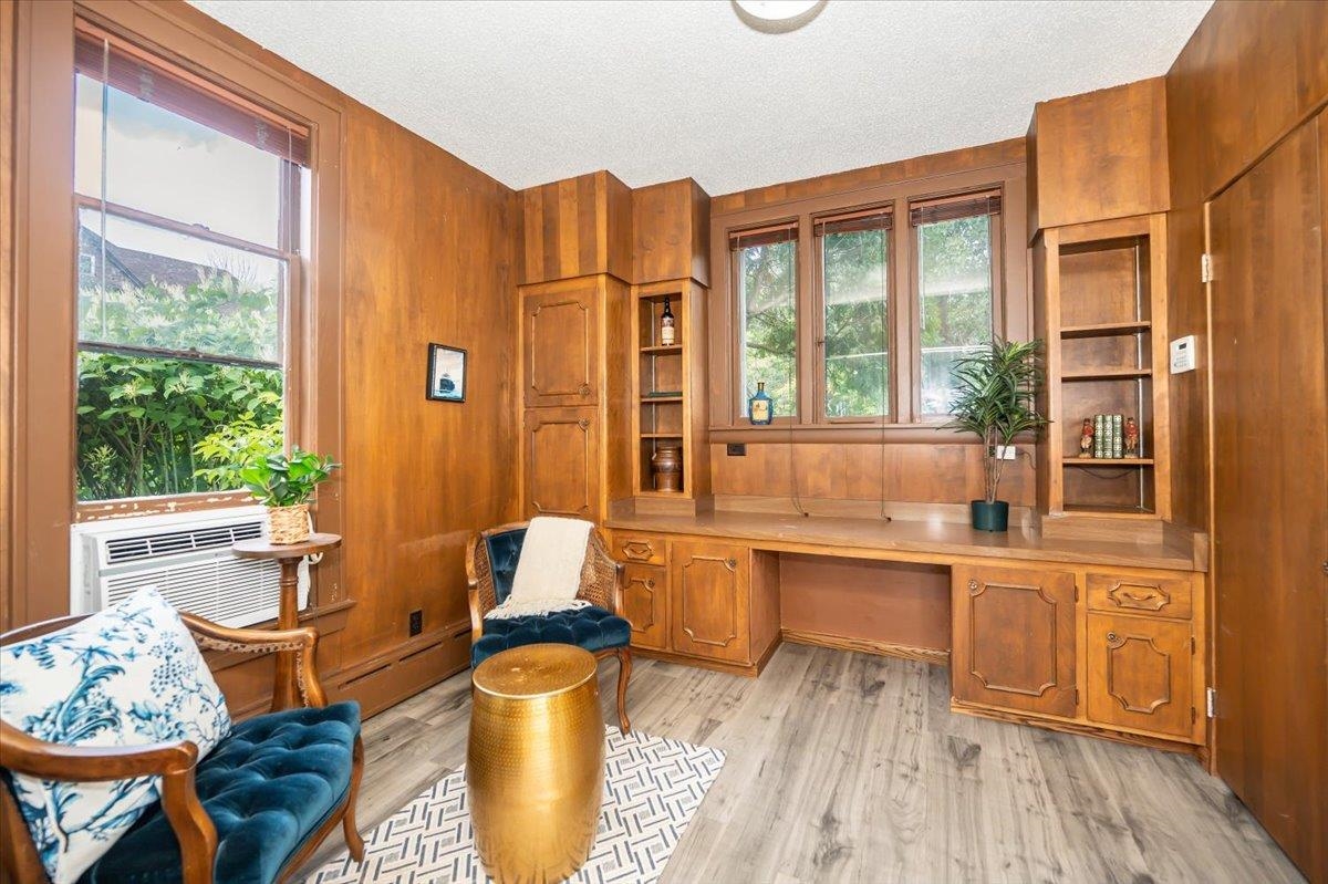 5130 London Road Duluth, MN 55804 - Photo 17 of 45 Office area with built in study area, wooden walls, a baseboard radiator, light wood-type flooring, and a textured ceiling