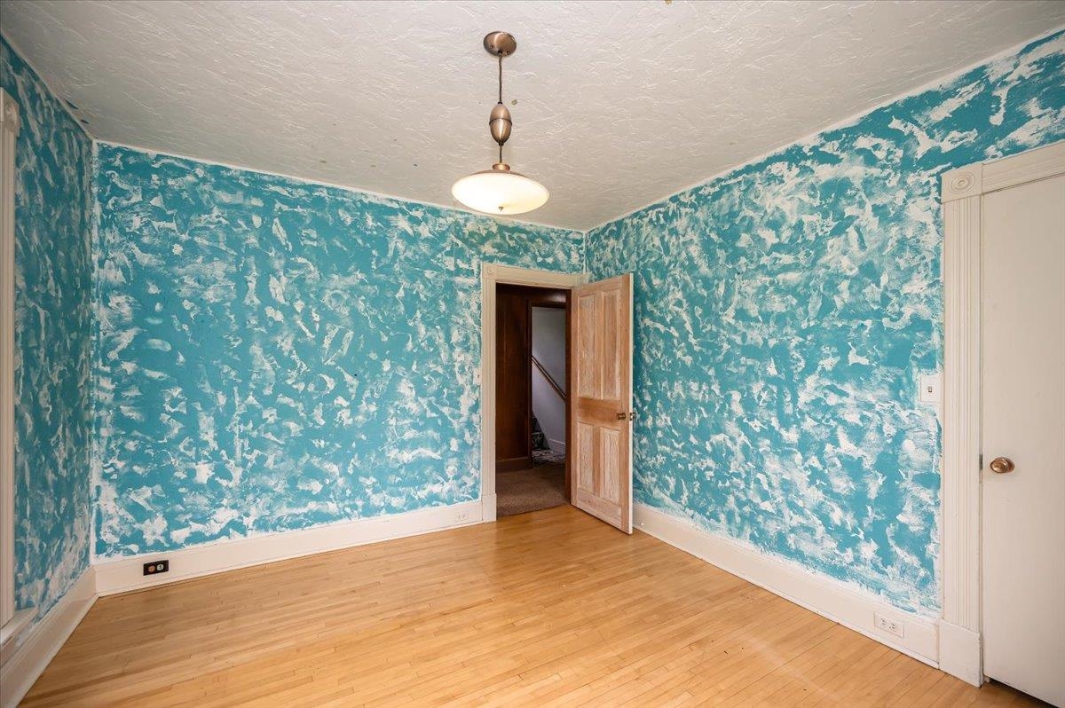 5130 London Road Duluth, MN 55804 - Photo 31 of 45 Spare room featuring wood finished floors, wallpapered walls, and a textured ceiling