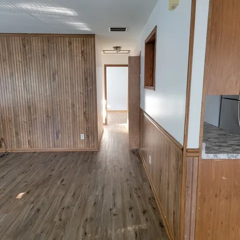 a view of a hallway with wooden floor and staircase