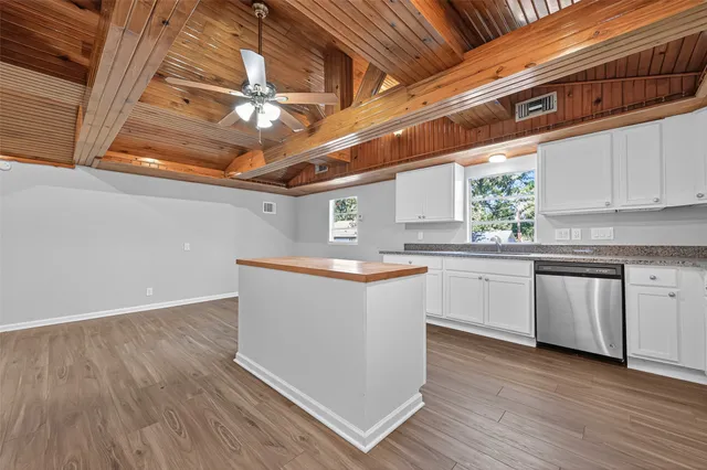 a kitchen with granite countertop a white stove top oven and cabinets
