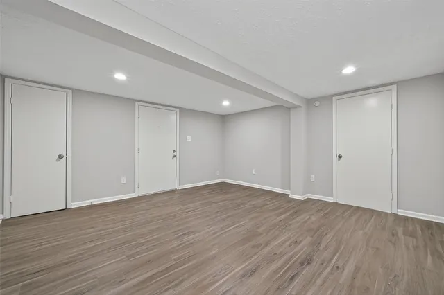 a view of an empty room with wooden floor