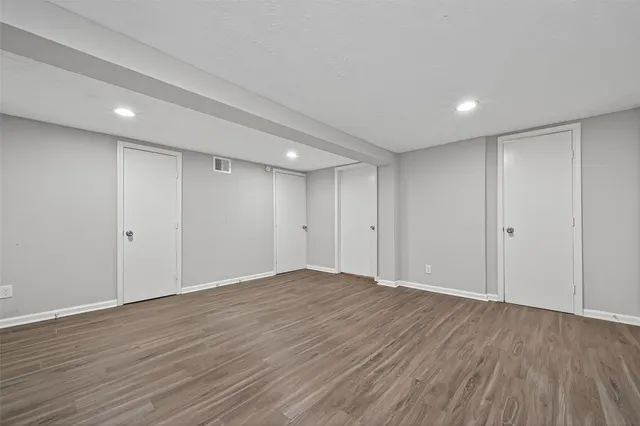 a view of an empty room with wooden floor