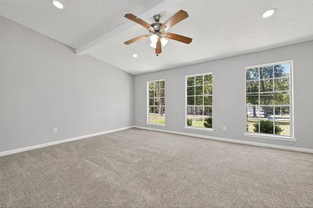 an empty room with window and a ceiling fan
