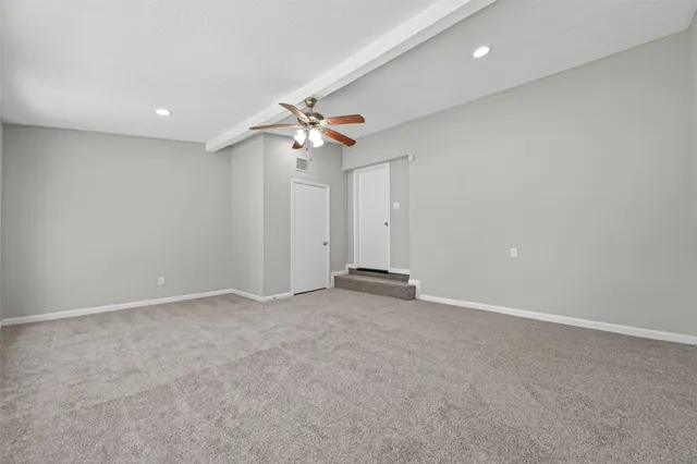 an empty room with a ceiling fan and a chandelier fan