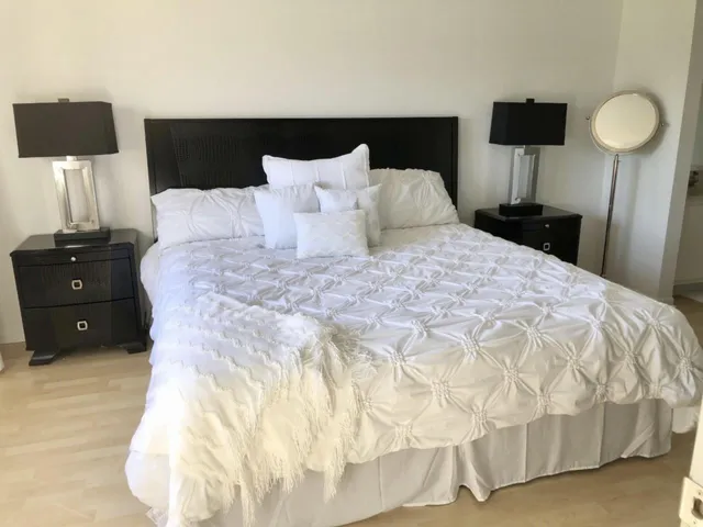 a bedroom with a bed and a large window