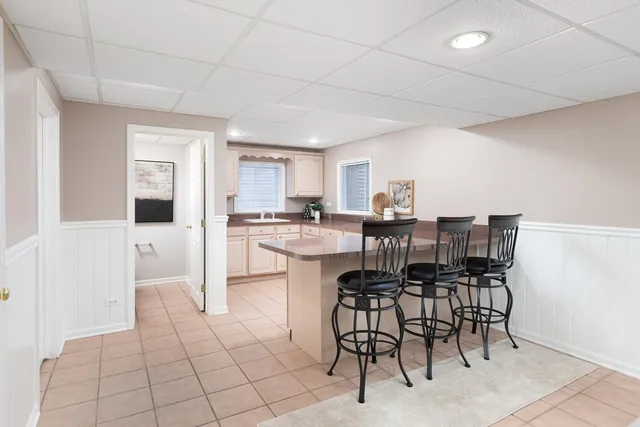 a kitchen with a dining table chairs cabinets and stainless steel appliances
