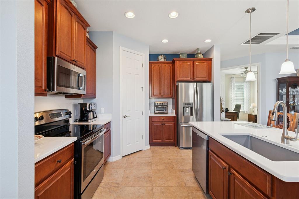 1689 Trabuco Canyon Court Kissimmee, FL 34759 - Photo 11 of 52 a kitchen with stainless steel appliances granite countertop a sink stove and refrigerator