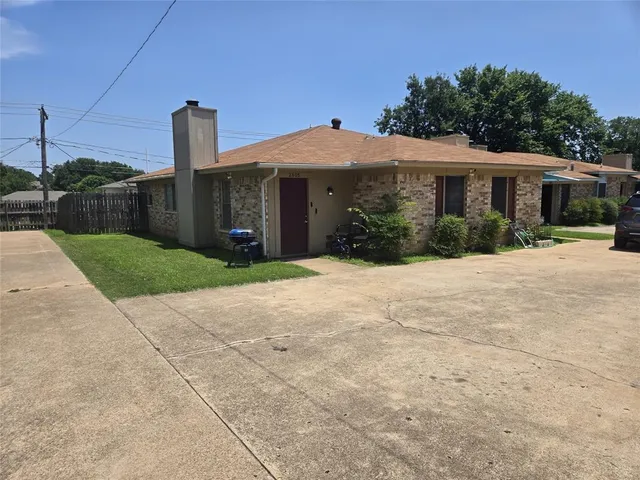 a front view of a house with a yard and potted plants