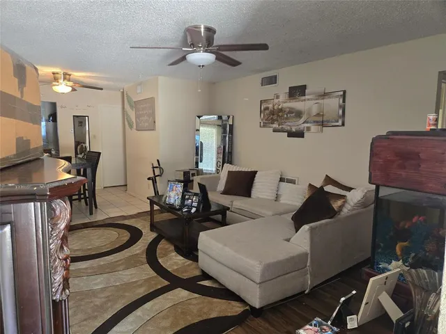 a living room with furniture a flat screen tv and kitchen view