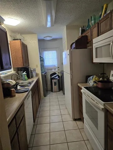 a kitchen with a sink a stove top oven and refrigerator