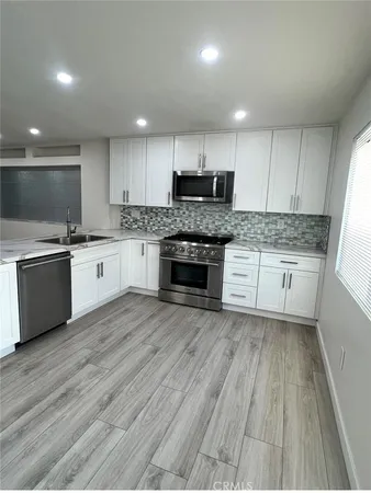 a kitchen with granite countertop a stove top oven and cabinets