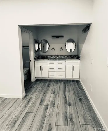 a kitchen with granite countertop white cabinets and wooden floor