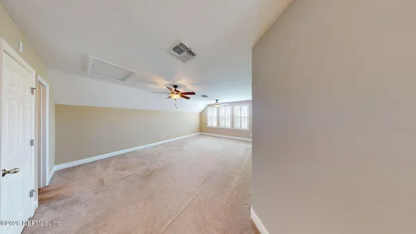 en empty room with windows and ceiling fan view
