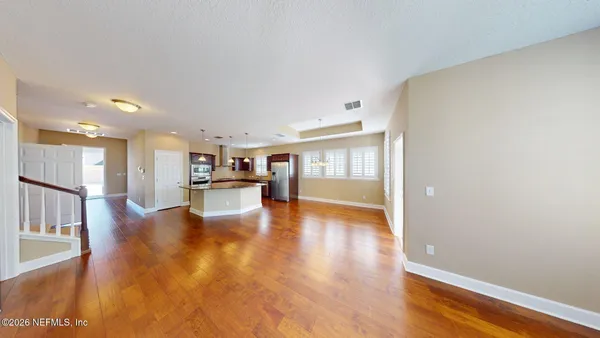 a view of a living room with wooden floor and a window