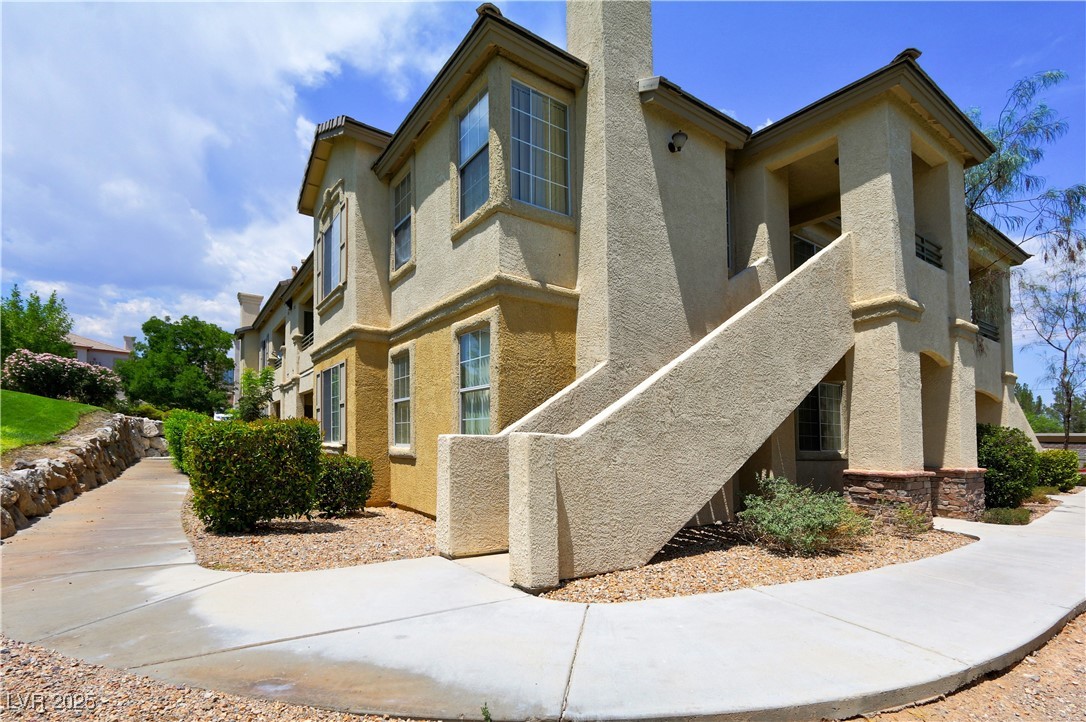 View of property exterior featuring stucco siding and a chimney