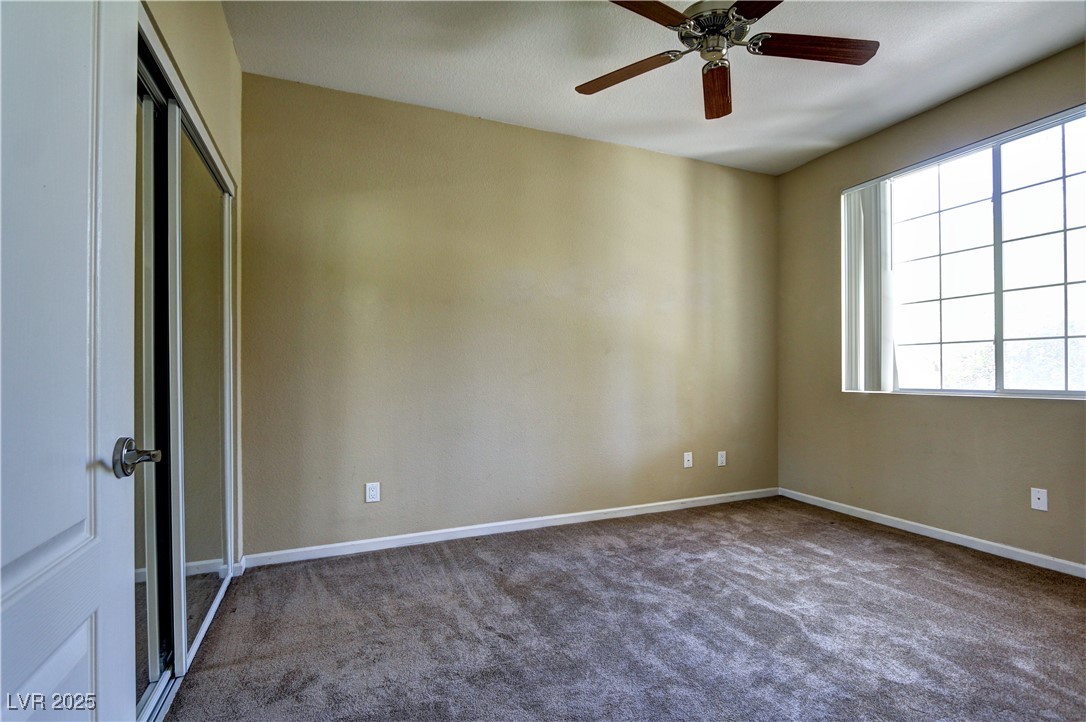 10225 King Henry Avenue, Unit 104 Las Vegas, NV 89144 - Photo 17 of 24 Unfurnished room with dark carpet and a ceiling fan
