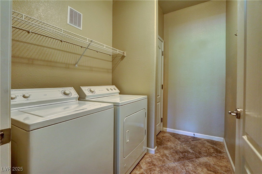 10225 King Henry Avenue, Unit 104 Las Vegas, NV 89144 - Photo 18 of 24 Laundry area with a textured wall, separate washer and dryer, and light tile patterned floors
