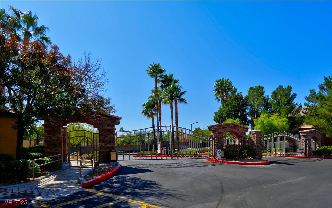 10225 King Henry Avenue, Unit 104 Las Vegas, NV 89144 - Photo 24 of 24 View of asphalt street featuring a gate, a gated entry, and curbs