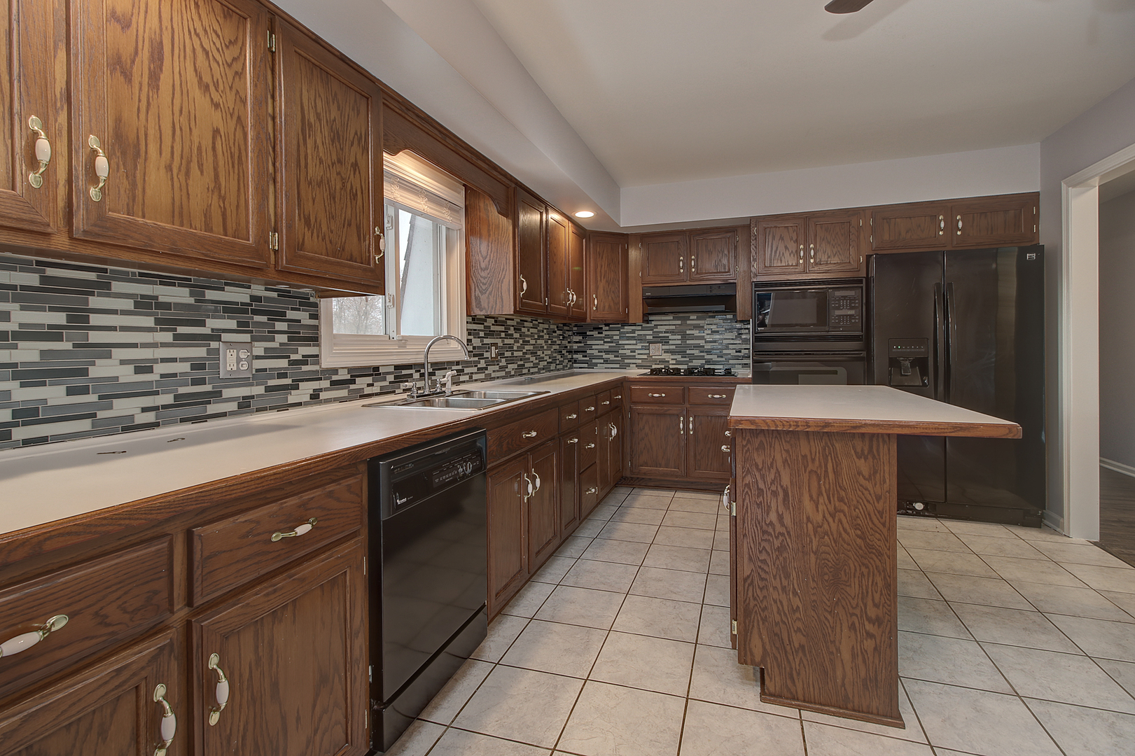 24218 West Main Street Plainfield, IL 60544 - Photo 7 of 19 a kitchen with stainless steel appliances granite countertop a sink counter space cabinets and a large window