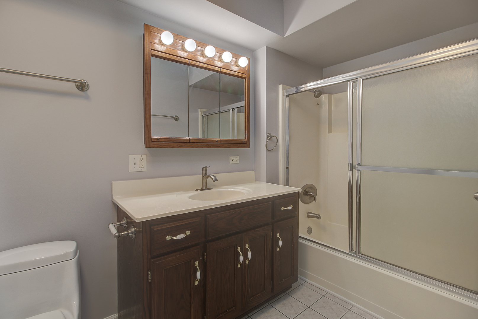 24218 West Main Street Plainfield, IL 60544 - Photo 10 of 19 a bathroom with a toilet a sink a vanity and mirror