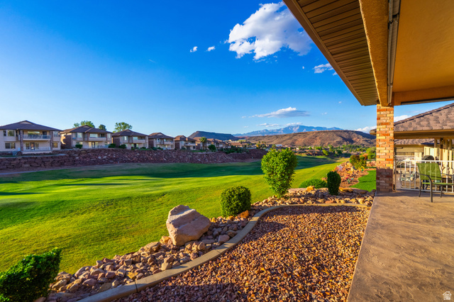 2212 Chippenham Court St. George, UT 84770 - Photo 28 of 75 View of green lawn featuring a patio area, view of golf course, a mountain view, and a residential view