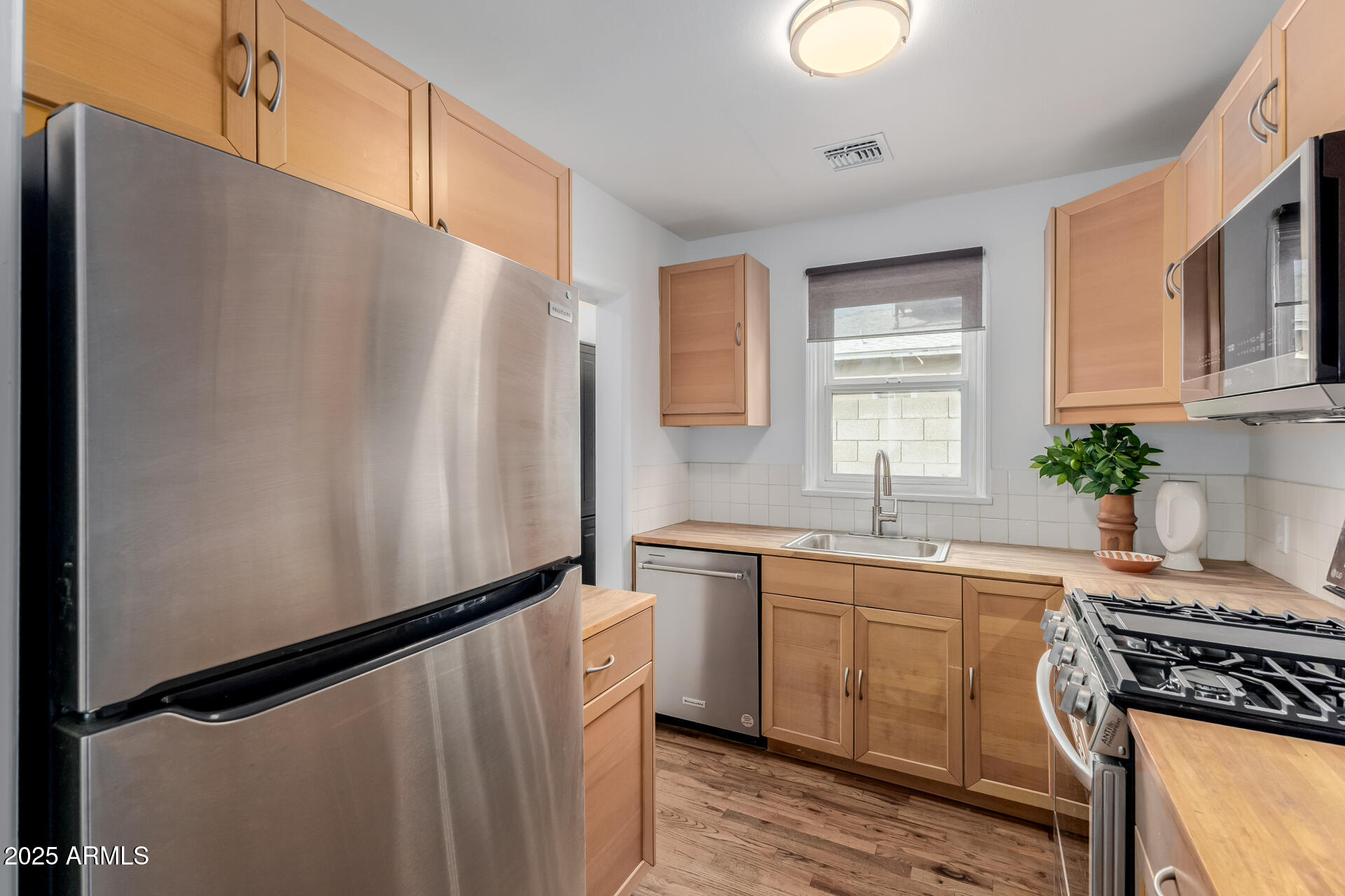 1305 East Granada Road Phoenix, AZ 85006 - Photo 10 of 35 a kitchen with stainless steel appliances a sink a stove a refrigerator and cabinets