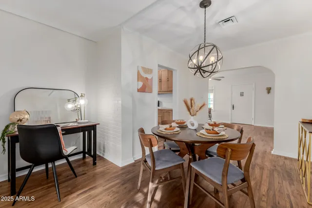 a view of a dining room and livingroom with furniture wooden floor a chandelier
