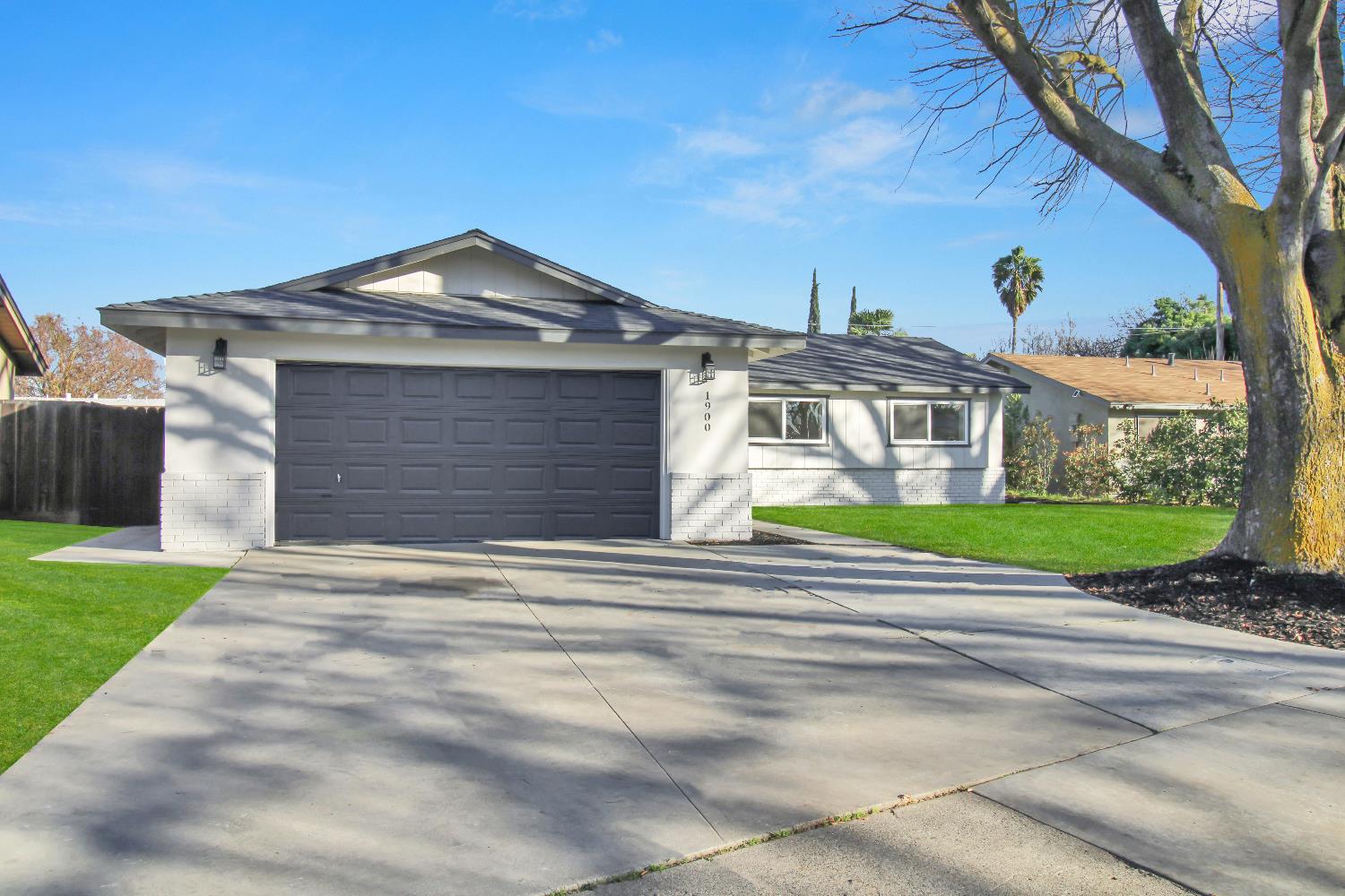 a front view of a house with a garden and trees