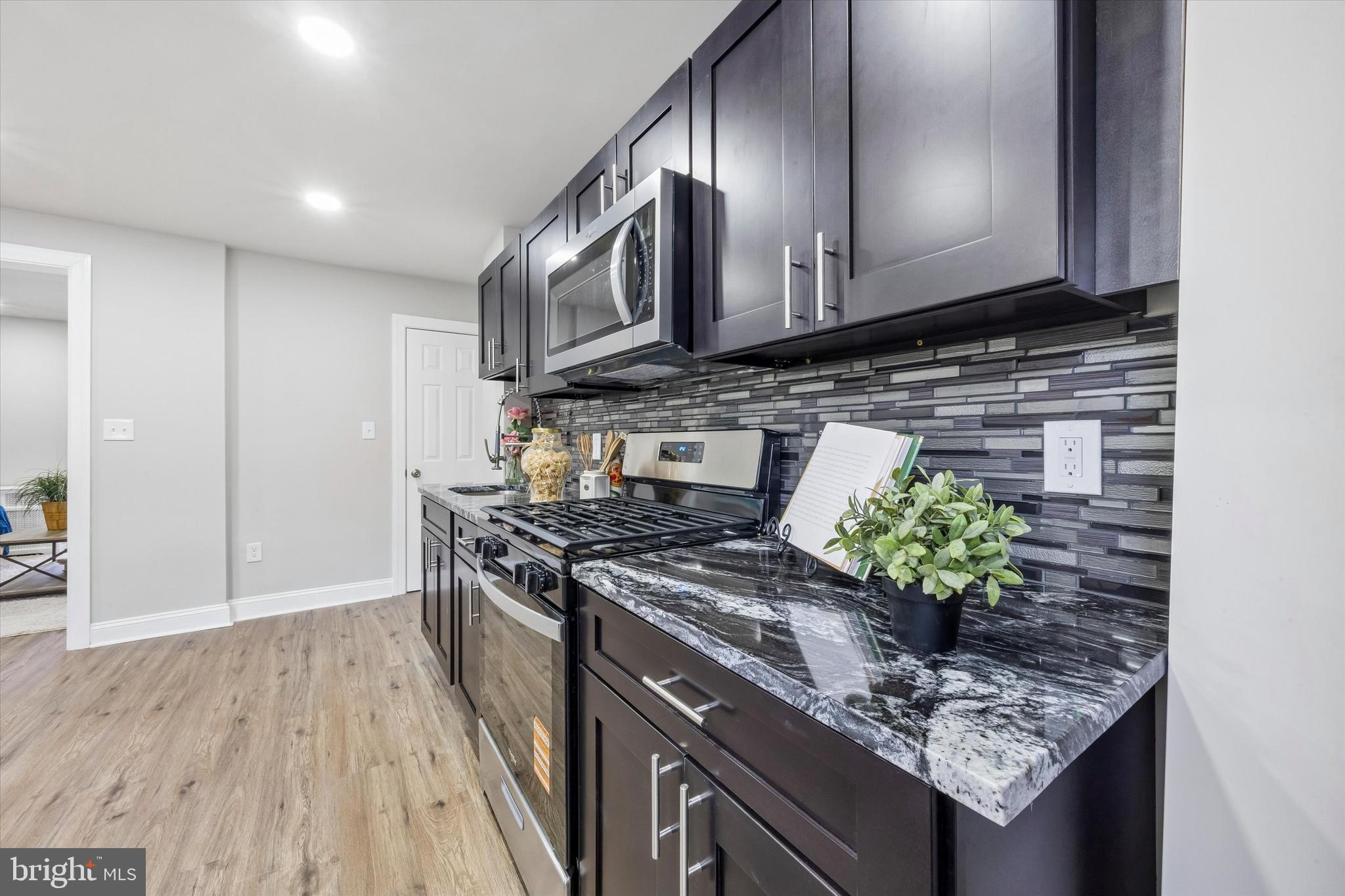 519 Littlecroft Road Upper Darby, PA 19082 - Photo 3 of 12 a kitchen with stainless steel appliances granite countertop a stove a sink and a microwave