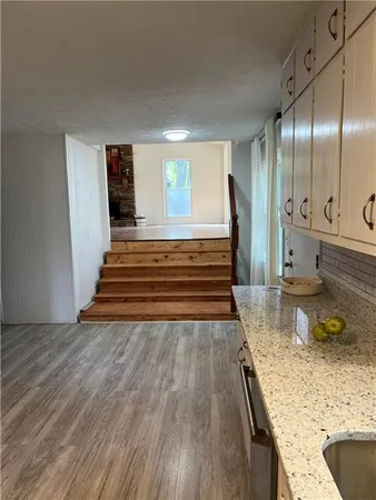 a view of a kitchen with granite countertop a sink and a stove