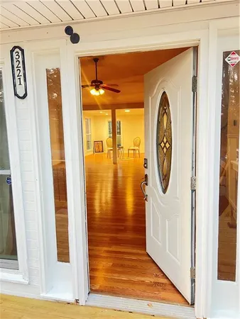 a view of a hallway with wooden floor and door