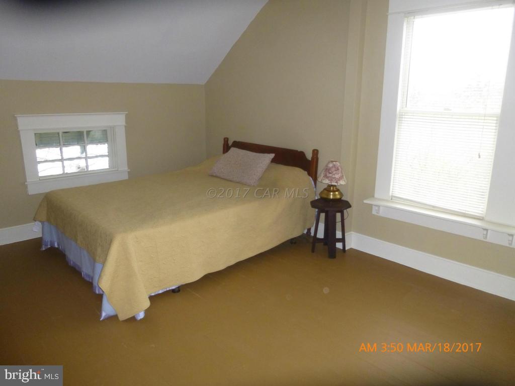 23468 Deal Island Road Deal Island, MD 21821 - Photo 14 of 20 a bed sitting in a room next to a window