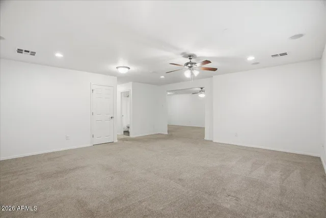 an empty room with a ceiling fan and window