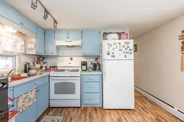 a kitchen with a white stove top oven and refrigerator